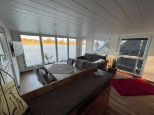 a living room with a couch and a table on a boat at Hausboot Optima in Wangerland