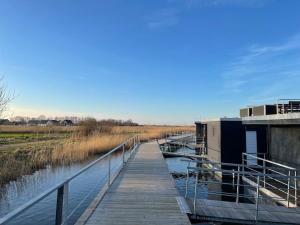 a wooden bridge over a body of water at Hausboot Optima in Wangerland