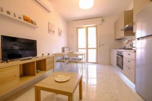 una cucina con televisore e tavolo in una stanza di Orchidea Luxury - Pineto Vacanza a Pineto