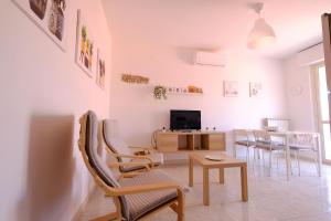 un soggiorno con sedie, tavolo e TV di Orchidea Luxury - Pineto Vacanza a Pineto