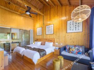 una camera con letto e ventilatore a soffitto di Floral Hotel Flower Sea Ninghai a Ch'a-lu-chieh