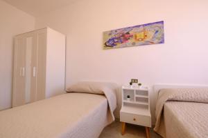 una camera da letto con due letti e un dipinto sul muro di Orchidea Luxury - Pineto Vacanza a Pineto