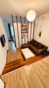 salon z kanapą i drewnianą podłogą w obiekcie Blue Sun w Lublanie