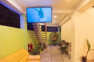 a living room with a yellow couch and a flat screen tv at Turtle Maldives in Omadhoo