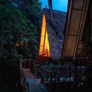 a house with a lit up window and trees at Khao Sok Paradise Resort in Khao Sok
