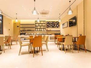 restauracja ze stołami i krzesłami oraz kuchnia w obiekcie City Comfort Inn Nanning Yudong Jinxiang Metro Station w mieście Nanning