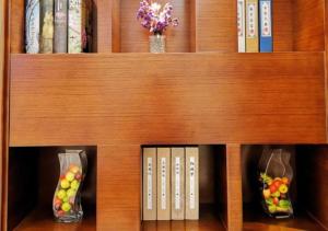 ein hölzernes Bücherregal mit Büchern und Obst darin in der Unterkunft City Comfort Inn Baise Tiandong in T'ien-tung