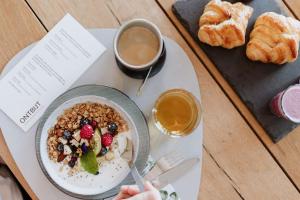 een tafel met een bord ontbijtproducten en een kopje koffie bij HEI15 in Sint Geertruid