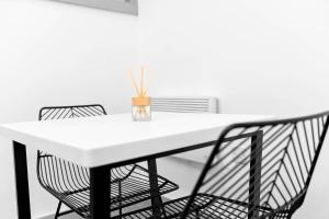 New Apartment in Brierley Hill - Parking - Wifi - Netflix - Top Rated - 309O في برمنغهام: طاولة بيضاء عليها كرسيين و مزهرية