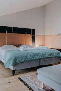 een slaapkamer met een bed met een groen dekbed bij HEI15 in Sint Geertruid