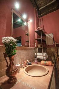 ein Badezimmer mit einem Waschbecken und einer Vase mit Blumen in der Unterkunft villa Pedriza II in Mataelpino