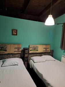 2 Betten in einem Zimmer mit blauer Wand in der Unterkunft villa Pedriza II in Mataelpino