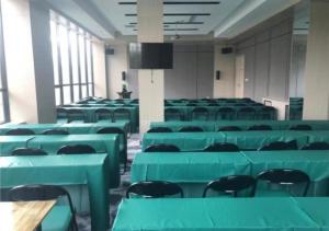 una habitación vacía con mesas verdes y sillas en City Comfort Inn Hotel Changchun Puyang Street FAW Automotive Trade City, en Changchún