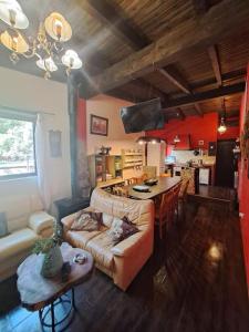 ein Wohnzimmer mit einem Sofa und einem Tisch sowie eine Küche in der Unterkunft villa Pedriza II in Mataelpino