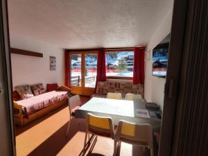 a living room with a table and chairs and a couch at Résidence Pelvoux - Studio pour 4 Personnes 844 in Aime-La Plagne
