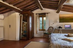 - une chambre avec un lit et une chaise dans l'établissement Casa Alloro, à Sinalunga