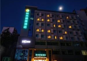 a tall building with a sign on it at night at City Comfort Inn Shiyan Walking Street in Shiyan