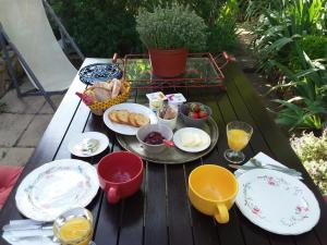 a picnic table with plates of food on it at Chambre d'hôtes ici in Bédoin