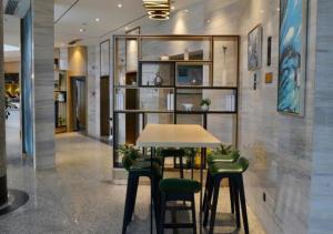 YulinにあるCity Comfort Inn Yulin Yufu Road Industrial Products Marketのテーブルと緑の椅子が備わる客室です。
