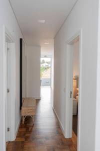 a hallway with white walls and a wooden floor at Achada Sol in Funchal