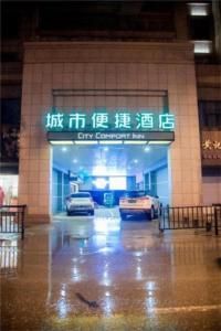 a building with cars parked in a parking lot at City Comfort Inn Jingdezhen Walking Street Yuyaochang in Jingdezhen