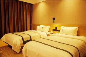 two beds in a hotel room at City Comfort Inn Jingdezhen Walking Street Yuyaochang in Jingdezhen