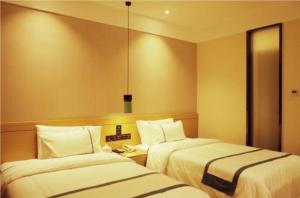 ein Hotelzimmer mit 2 Betten und einem Telefon in der Unterkunft City Comfort Inn Jingdezhen Walking Street Yuyaochang in Jingdezhen