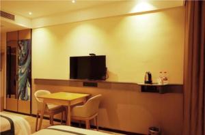 ein Hotelzimmer mit einem kleinen Tisch und einem TV in der Unterkunft City Comfort Inn Jingdezhen Walking Street Yuyaochang in Jingdezhen