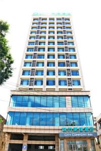 un edificio alto con ventanas de cristal azul. en City Comfort Inn Zhanjiang Xuwen Port Wharf Passenger Station en Xuwen