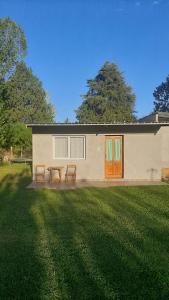 a house with two benches in front of a yard at Paz y Vino in Ciudad Lujan de Cuyo