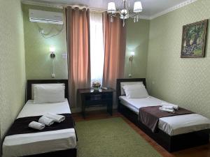 una camera d'albergo con due letti e una finestra di Hotel Euro Asia Khiva in Ichan Qala a Khiva