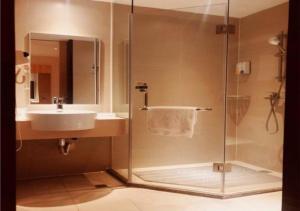 W łazience znajduje się umywalka i prysznic. w obiekcie City Comfort Inn Zhuhai Jinwan Hangkong Xincheng w mieście Baigaonongchang