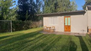 a small house with a table and chairs in a yard at Paz y Vino in Ciudad Lujan de Cuyo