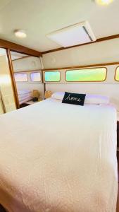 a large white bed in a room with windows at Yacht y fiestas in Barcelona