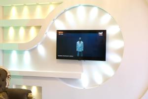 a tv on a wall with a mirror at GRAND CLOVER otel in Seyhan