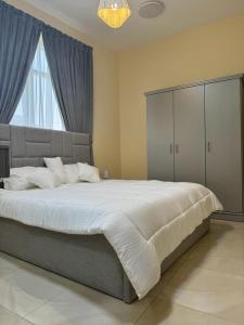 a bedroom with a large bed and a large window at Star building in Khor Fakkan