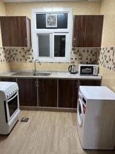 a kitchen with a sink and a stove and a microwave at Star building in Khor Fakkan