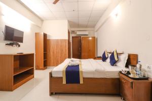 um quarto com uma cama e uma televisão em Hotel PARAS TOWER em Dehradun