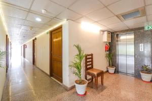 un corridoio dell'ufficio con sedia e piante in vaso di Hotel PARAS TOWER a Dehradun