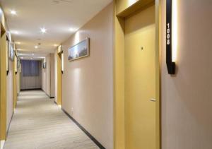 a hallway of a hospital with yellow walls and a hallwayngthngthngthngthngth at City Comfort Inn Jingzhou Hongxing Road Food Street in Pu-ho