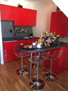 a red kitchen with a black counter and red cabinets at Cannes Centre Palais du Festival in Cannes