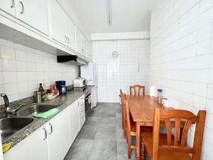 eine Küche mit einem Holztisch und Stühlen in der Unterkunft Vibes Coruña-Tovar 42 in A Coruña