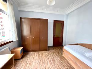 Schlafzimmer mit einem Bett und einem Holzschrank in der Unterkunft Vibes Coruña-Tovar 42 in A Coruña