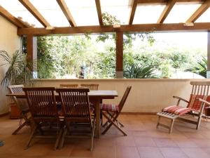 un patio con mesa de madera y sillas en Villa Turandot-swimming pool-close to the beach, en Torre delle Stelle