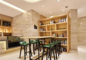 a kitchen with a bar with green stools at City Comfort Inn Liuzhou Liunan Wanda RT-Mart in Liuzhou