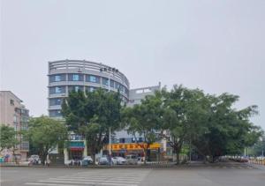un gran edificio con árboles frente a un aparcamiento en City Comfort Inn Liuzhou Liunan Wanda RT-Mart en Liuzhou