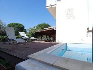una terraza con 2 sillas y una piscina en Villa Turandot-swimming pool-close to the beach, en Torre delle Stelle