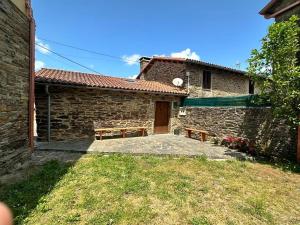 a stone house with two benches in front of it at Casal de Pedra in Santa Irene