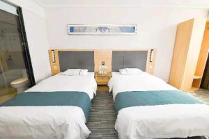 two beds in a hotel room with at City Comfort Inn Zhenjiang Dashikou Suning Plaza in Zhenjiang