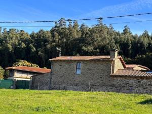 a brick house in a field with trees in the background at Casal de Pedra in Santa Irene